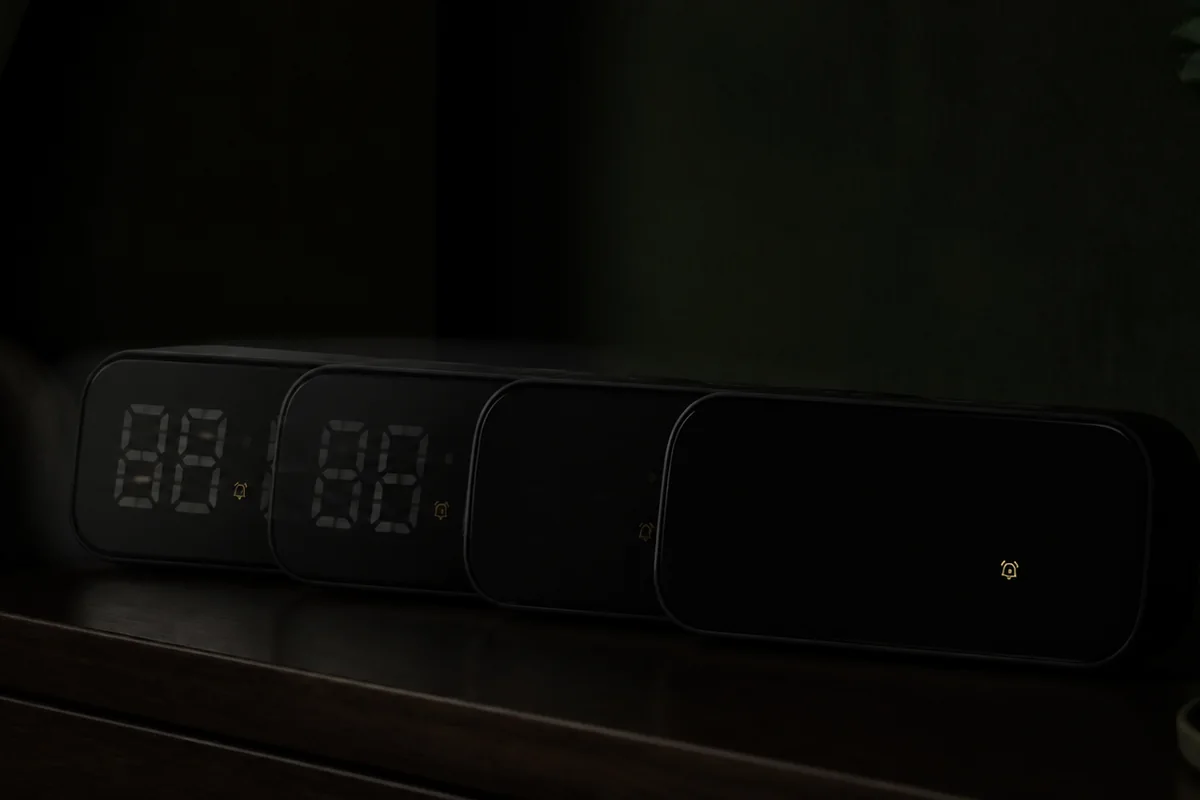 Alarm clock moving from dim digits to a true display-off state in a dark bedroom