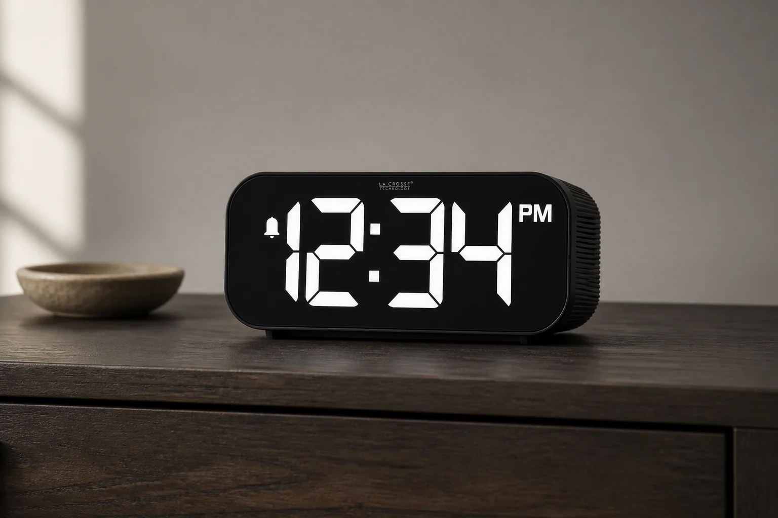 La Crosse Technology 617-714 alarm clock with a large white display on a dark bedside table
