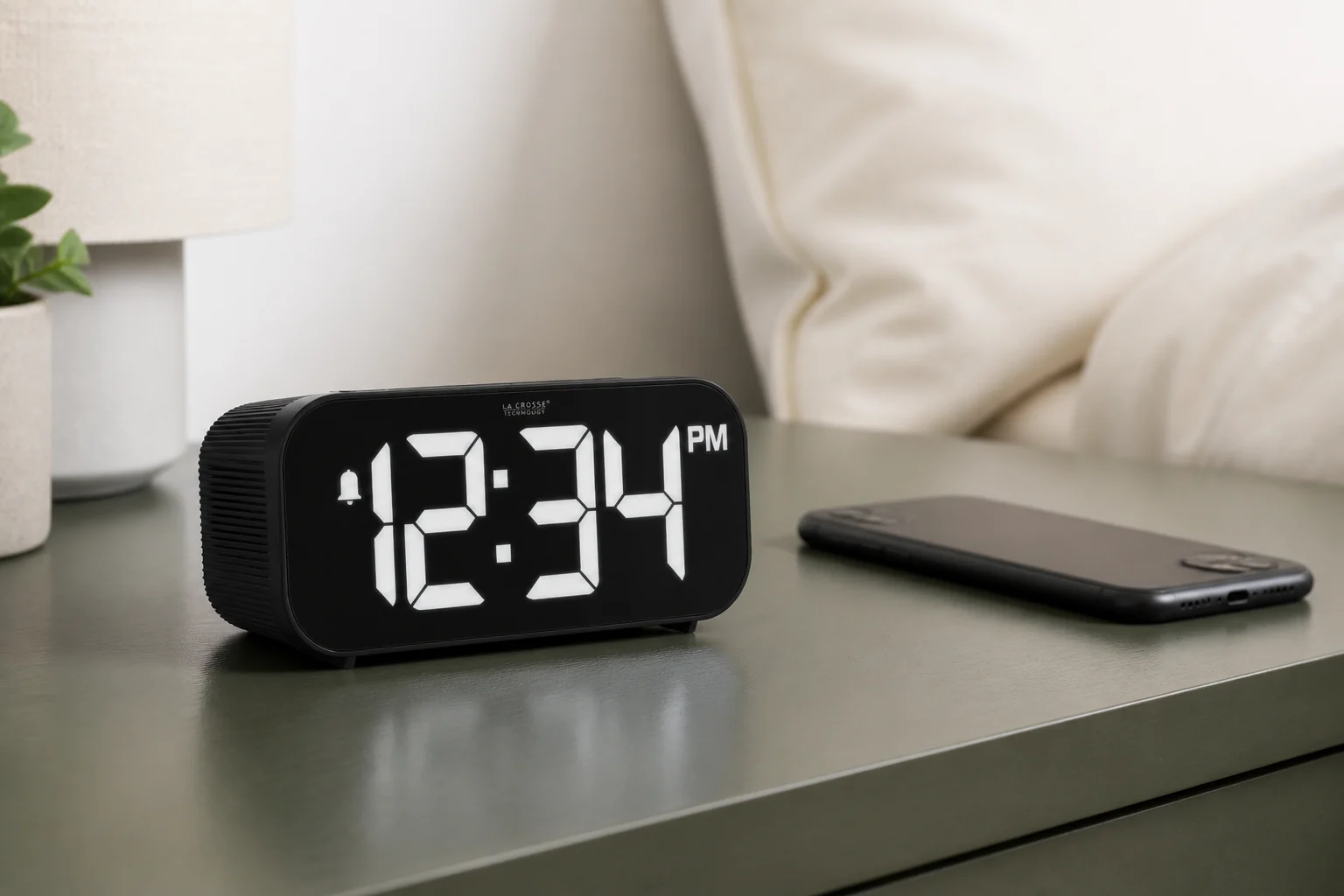 La Crosse Technology 617-714 digital alarm clock beside a face-down smartphone