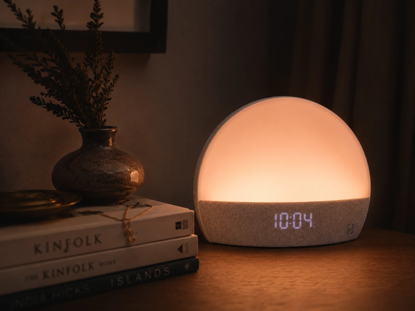 Hatch Restore Smart Alarm Clock casting a soft ambient glow on a nightstand
