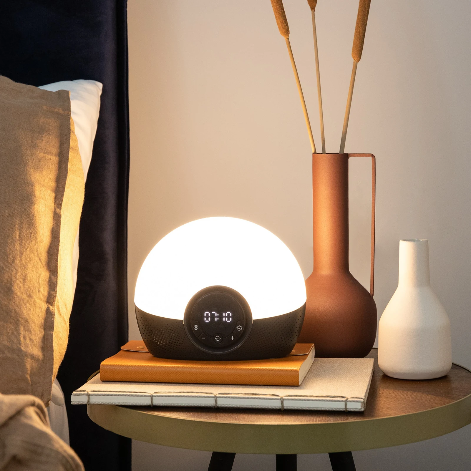 Exact Lumie Bodyclock Glow 150 glowing warm white on a bedside table